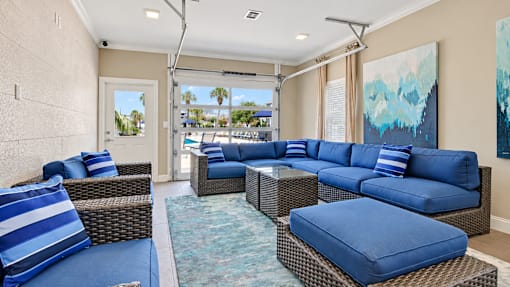 Resident lounge with blue cushioned seating, wicker tables and counter seating at Canterbury Apartments in Myrtle Beach, SC.