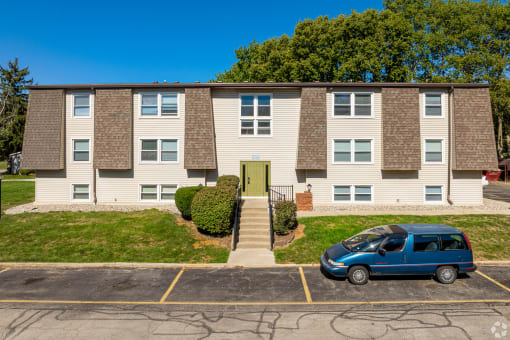 an apartment building with a blue van parked in front of it