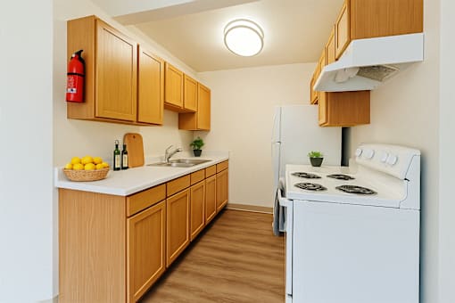A kitchen with wooden cabinets and a white refrigerator.