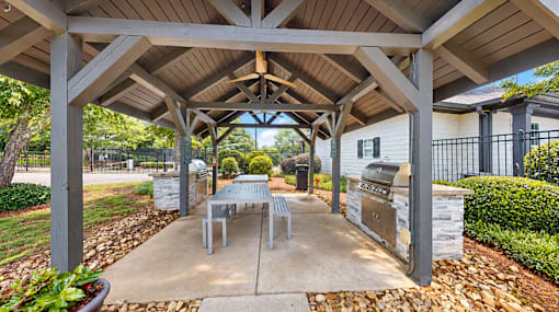 Covered outdoor pavilion with two built-in grills and picnic tables at Icon Cartersville Apartments.