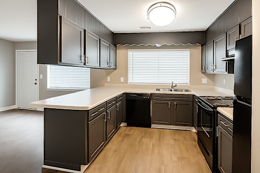 A kitchen with black cabinets and a white countertop.