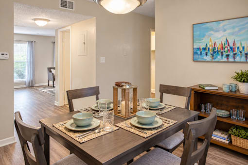 Dining area with wood-style flooring and space for a four-person table at Madison Park Apartments & Townhomes in Birmingham, AL.