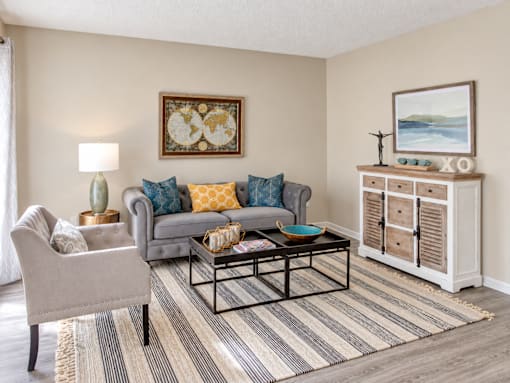 Apartment living room with wood-style flooring and spacious seating area at Madison Park Apartments & Townhomes in Birmingham, AL.