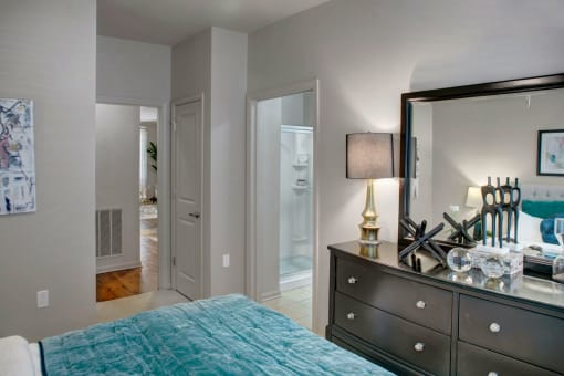 a bedroom with a bed and a dresser with a mirror