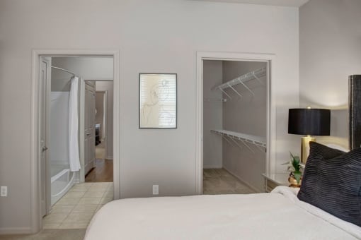 a bedroom with a large bed and a closet with a mirrored door