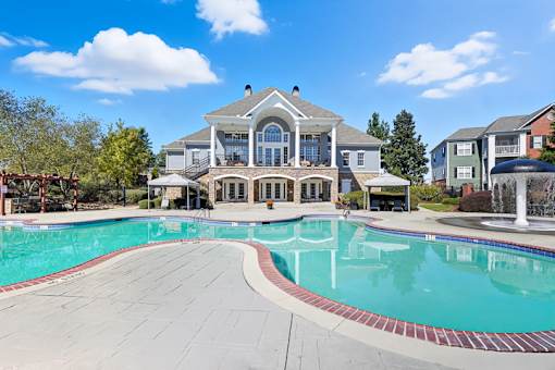 A large house with a pool in front.