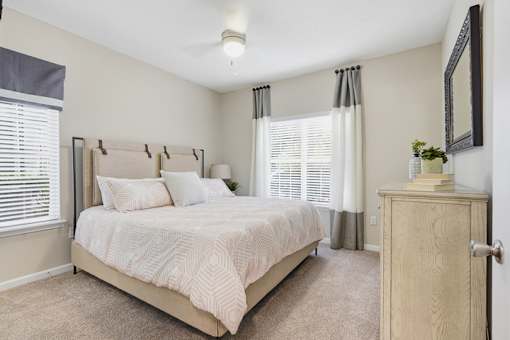 A bedroom with a large bed and a wooden cabinet.