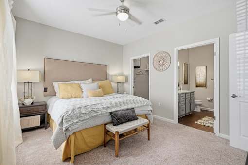 A bedroom with a bed, nightstands, and a ceiling fan.
