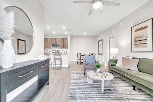A modern living room with a grey sofa, a white coffee table, and a grey and white rug.