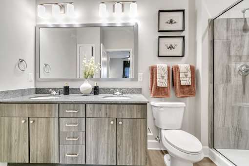 A bathroom with a white toilet, a mirror, and a shower.