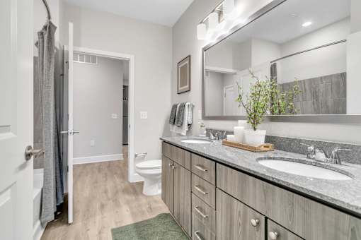 A bathroom with a toilet, sink, and mirror.