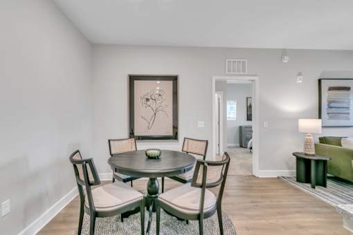 A dining room with a table and chairs.