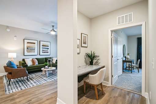 A living room with a green couch and a dining room with a table and chairs.