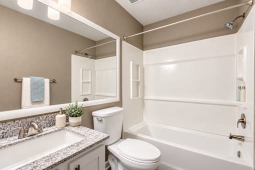 Bathroom with a rectangular sink, patterned countertop and bathtub at Waterchase Apartments in Largo, FL.