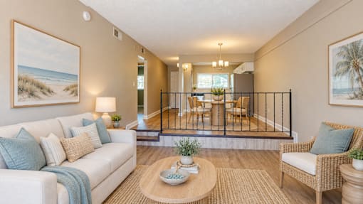 Virtually staged living room in the foreground and dining area behind it at Waterchase Apartments in Largo, FL.