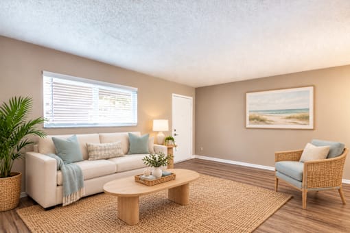Virtually staged living room with a sofa, accent chair and window at Waterchase Apartments in Largo, FL.