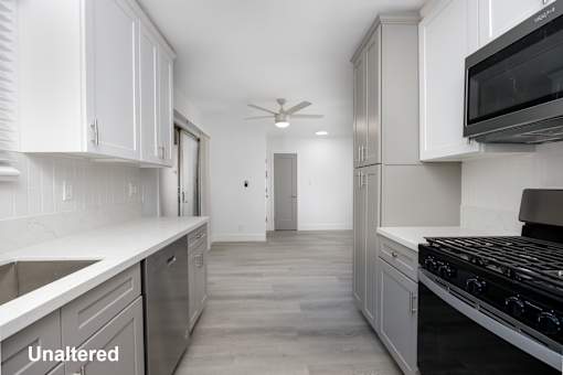 A kitchen with white cabinets and a black stove top oven.