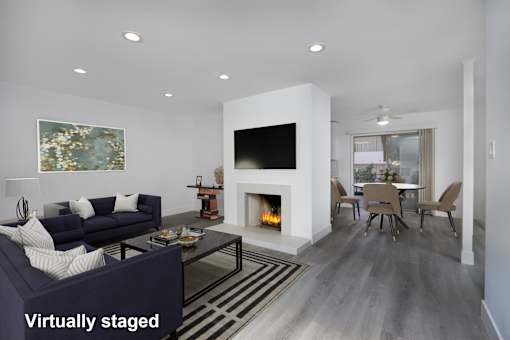 A modern living room with a fireplace and a painting on the wall.