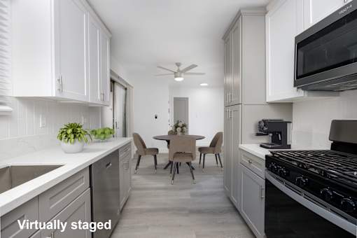 A kitchen with white cabinets and a black stove top oven.