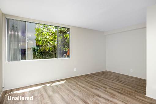A room with a window and wooden flooring.