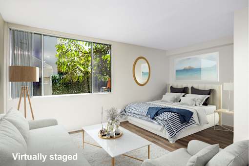 A modern bedroom with a large bed and a view of the outdoors.