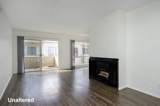 A room with a black fireplace and wooden floors.