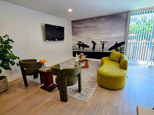 A living room with a surfer mural on the wall.