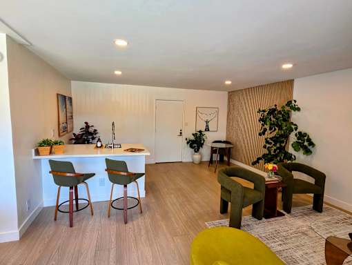 A living room with a bar area and a green chair.