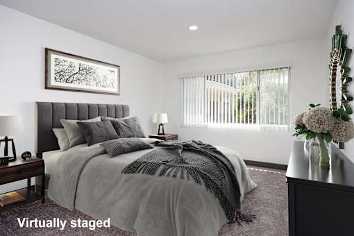 A bedroom with a large bed and a painting on the wall.