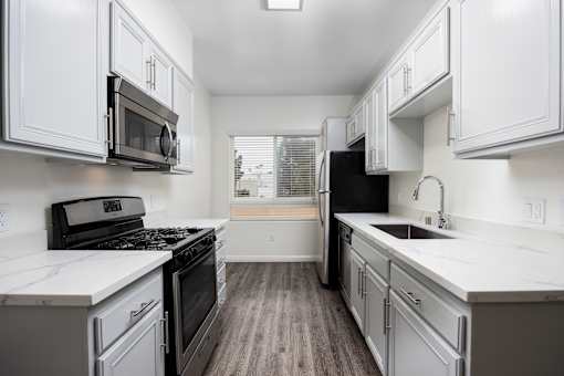 a kitchen with white cabinets and white countertops