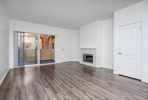 a bedroom with hardwood floors and white walls