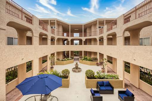 a courtyard with seating and a fountain in the middle of a building