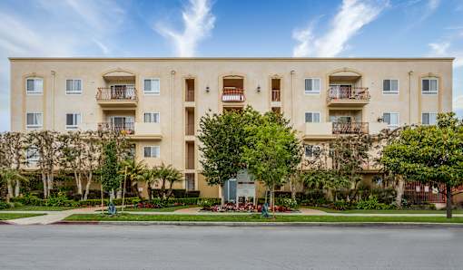 a large apartment building with trees in front of it