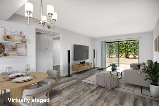 A modern living room with a dining table set for two and a flat screen TV.