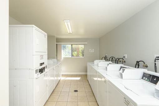 a kitchen with white counters and appliances and a window