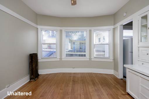 A room with unaltered wooden flooring and white walls.