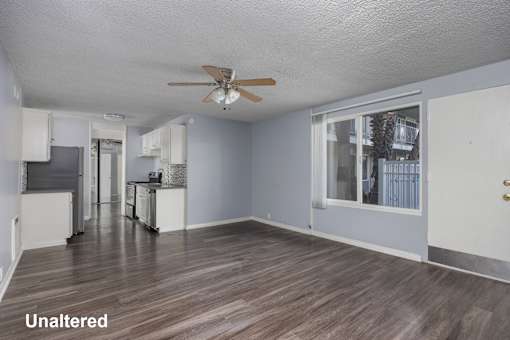 A room with a ceiling fan and wooden flooring.