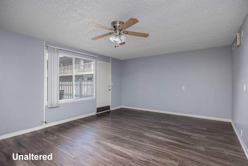 A room with a ceiling fan and a window with bars.