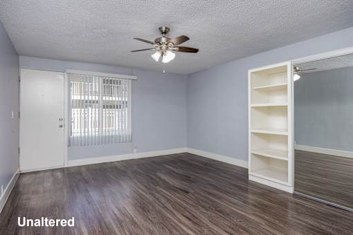 A room with a ceiling fan and a sliding door.