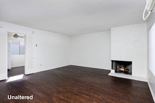 A room with a fireplace and wood floors.