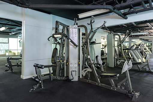 A gym with a variety of equipment including a leg press machine.