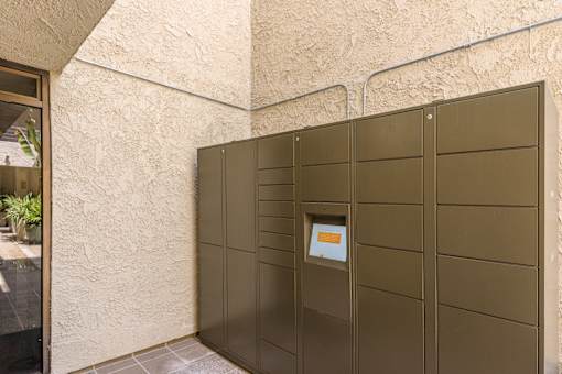 A brown metal gate with a small window in the middle.