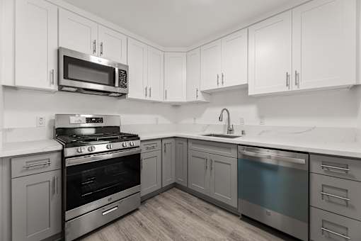 A kitchen with a stove, oven, and microwave.