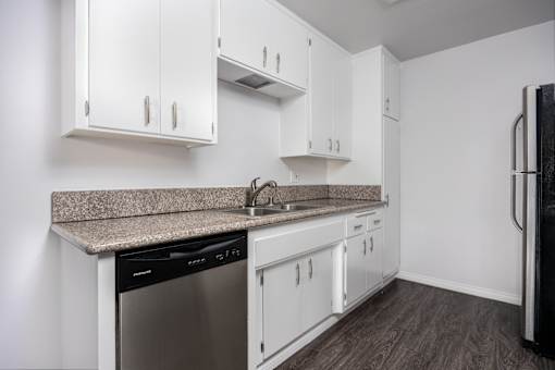 a kitchen with white cabinets and a granite counter top