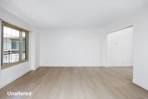 A room with unaltered wooden flooring and white walls.