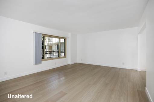A room with a window and wooden flooring.