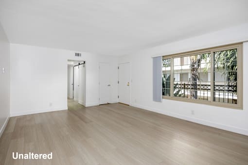 A room with unaltered flooring and a window showing a tree.