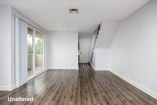 A room with unaltered wooden flooring and white walls.