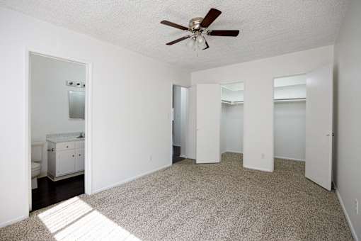 a living room with a rug and a ceiling fan