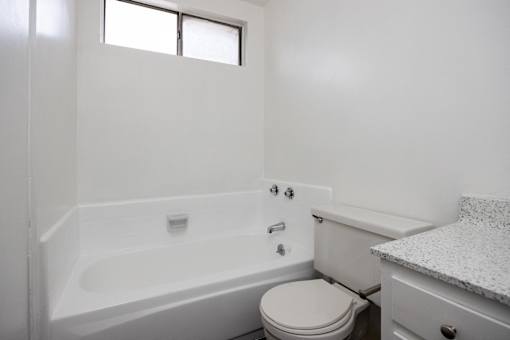 an empty bathroom with a toilet and a bath tub